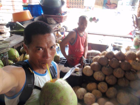 at the Dumaguete Public Market helping myself to a coconut - juice and coco meat...nature's goodness at P15!