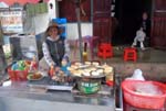 a street vendor selling grilled meat sandwiched in a rice patty